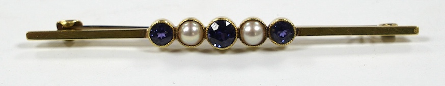 An Edwardian 15ct, three stone sapphire and two stone split pearl set bar brooch, 64mm, gross weight 3.4 grams. Condition - fair to good
